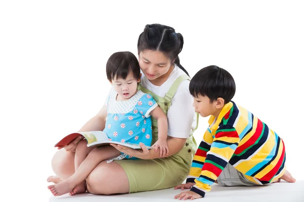 Young female with two little asian children reading a book — Stock Photo, Image