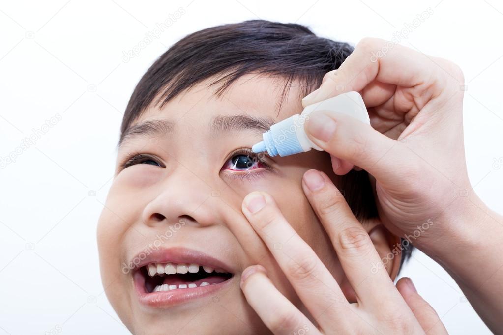 Closeup of parent pouring eye drops in eye her son
