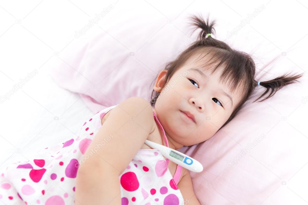 Little girl lying on sickbed with digital thermometer in her arm