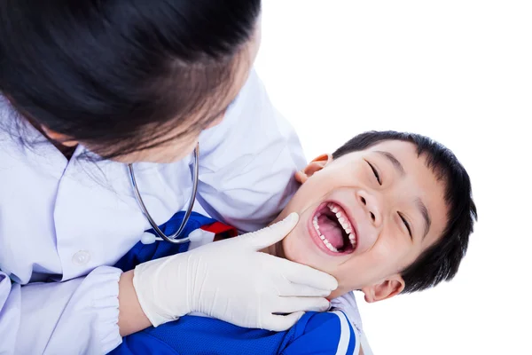 Jeune dentiste vérifiant la santé buccodentaire de l'enfant, isolé sur blanc b Image En Vente