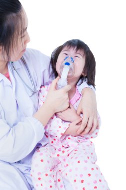 Doktor inhalasyon için küçük kız yardımcı olur.
