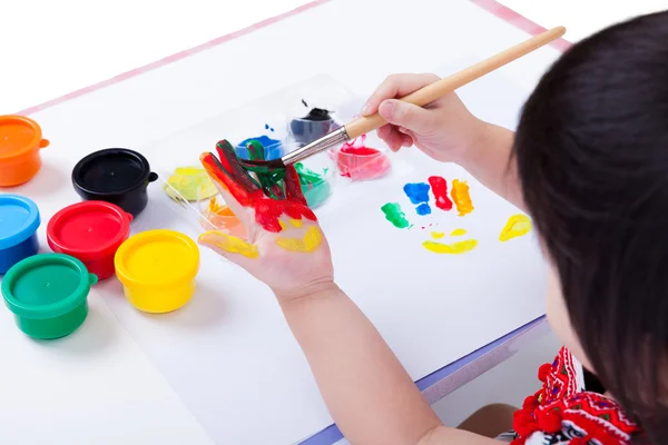 Asian girl painting her palm using drawing tools, art education — Stock Photo, Image
