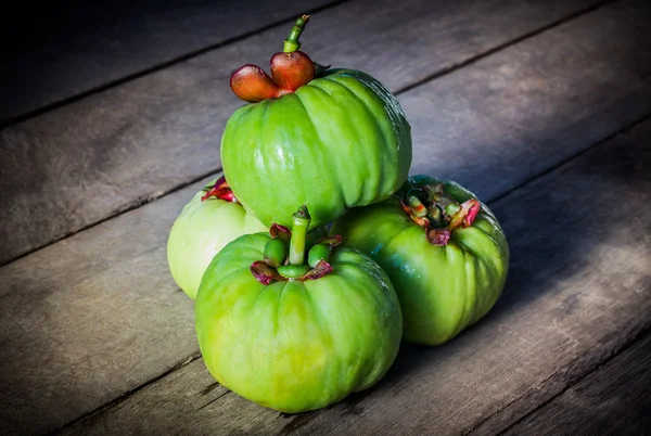 Still life with fresh garcinia cambogia on wooden background (Th — Stock Photo, Image