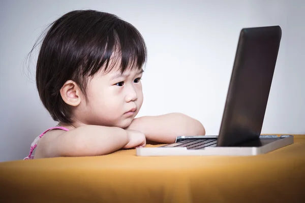 Enfant sérieux assis et regardant une histoire sur écran tactile numérique — Photo