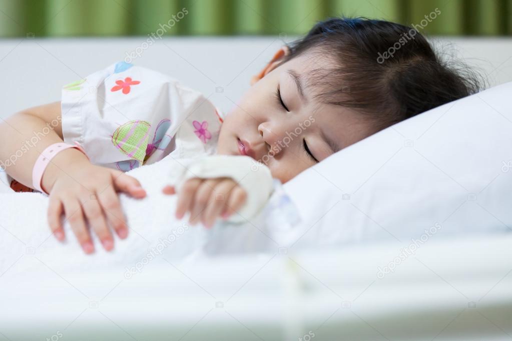 Illness child in hospital, saline intravenous (IV) on hand asian