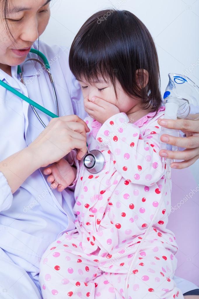 Doctor helps little asian girl taking respiratory, inhalation th