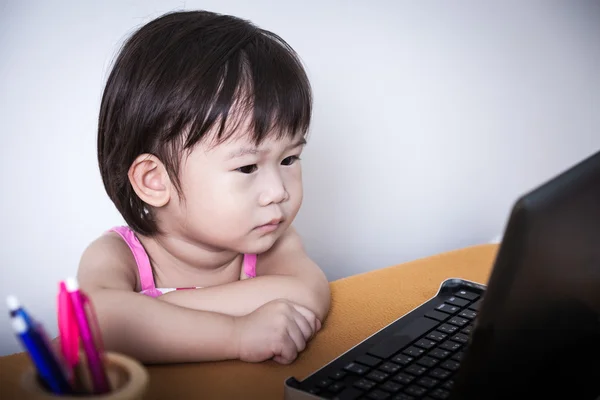 Schattig klein Aziatische (thai) meisje een verhaal over touchscree kijken — Stockfoto