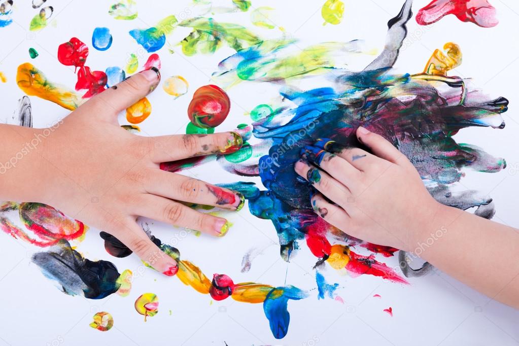 Closeup of little children hands doing finger painting with vari
