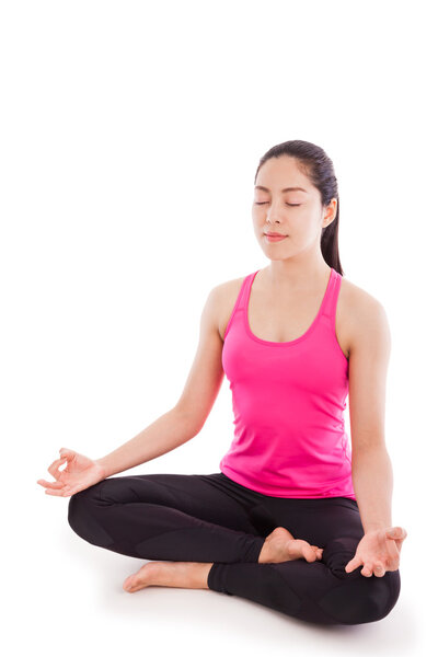 Beautiful young woman practicing yoga, sitting in a lotus positi