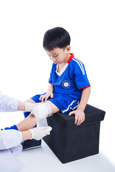 Jovem jogador de futebol asiático em uniforme azul. Dor nas articulações do joelho . — Fotografia de Stock