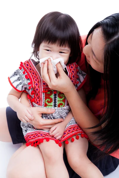 Asian mother wipes snot her daughter on white background — Stock Photo, Image
