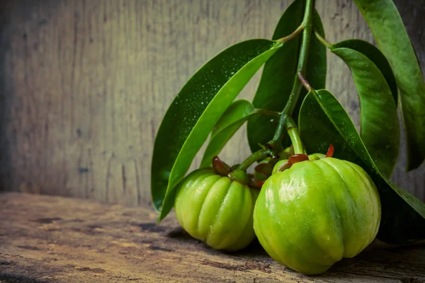 Stilleven met verse garcinia cambogia op houten achtergrond (Th — Stockfoto