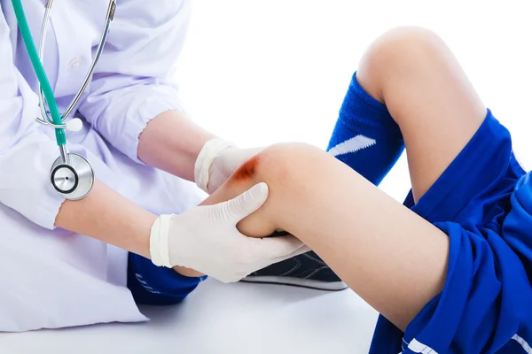 Doctor checking knee injury athlete, on white background. Studio — Stock Photo, Image