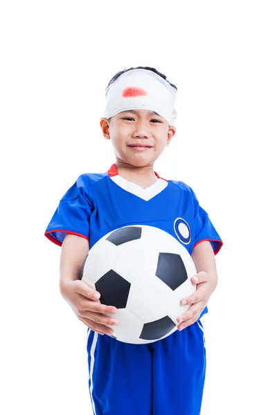 Азиатский ребенок с травмой головы, держа в руках футбол и крик — стоковое фото