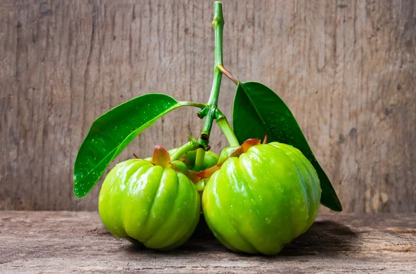 Natureza morta com garcinia cambogia fresco em fundo de madeira (Th — Fotografia de Stock