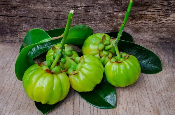 Natureza morta com garcinia cambogia fresco em fundo de madeira (Th — Fotografia de Stock