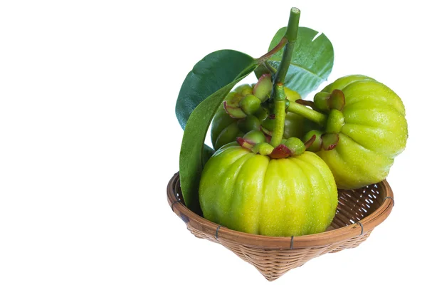 Bodegón con garcinia cambogia fresca en cesta de madera. Aislado —  Fotos de Stock