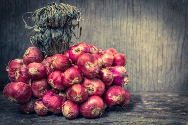 Bir grup eski ahşap zemin üzerine taze kırmızı soğan. Vintage PICT