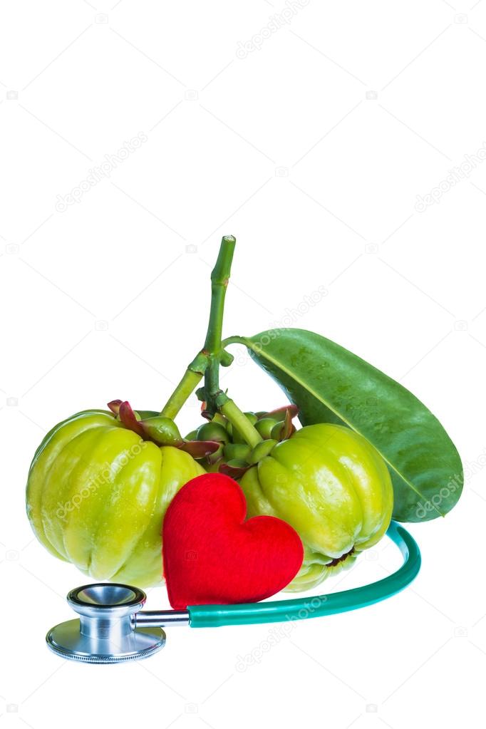 Garcinia cambogia, red heart-shaped and stethoscope on white bac