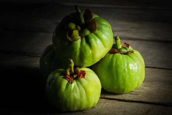 Bodegón con garcinia cambogia fresca sobre fondo de madera (Th — Foto de Stock