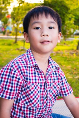 Asyalı çocuk rahatlatıcı parkta kapatın. Açık havada genç çocuk