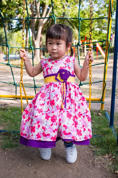 Diversão adorável menina no balanço no parque. Luz solar nas crianças pl — Fotografia de Stock