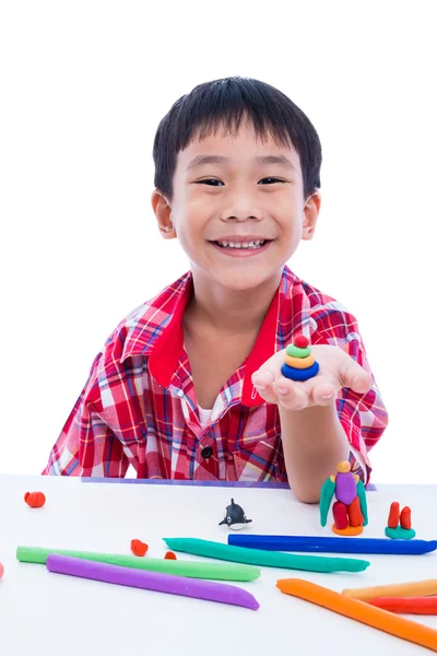 Niño sonriendo y mostrar sus obras de arcilla, sobre fondo blanco. — Foto de Stock