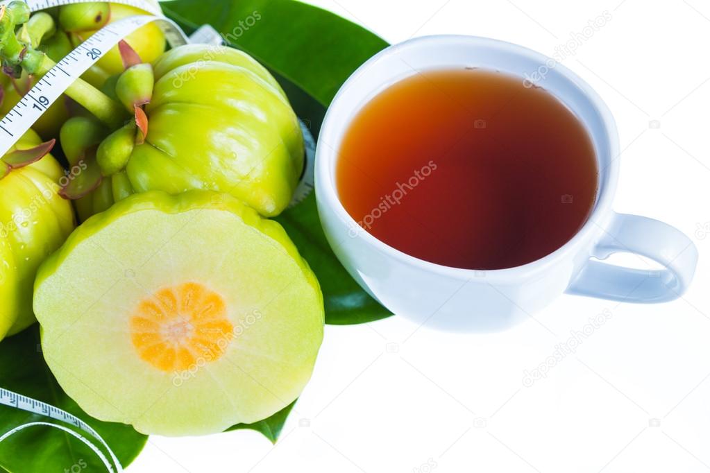 Garcinia cambogia with measuring tape, isolated on white background