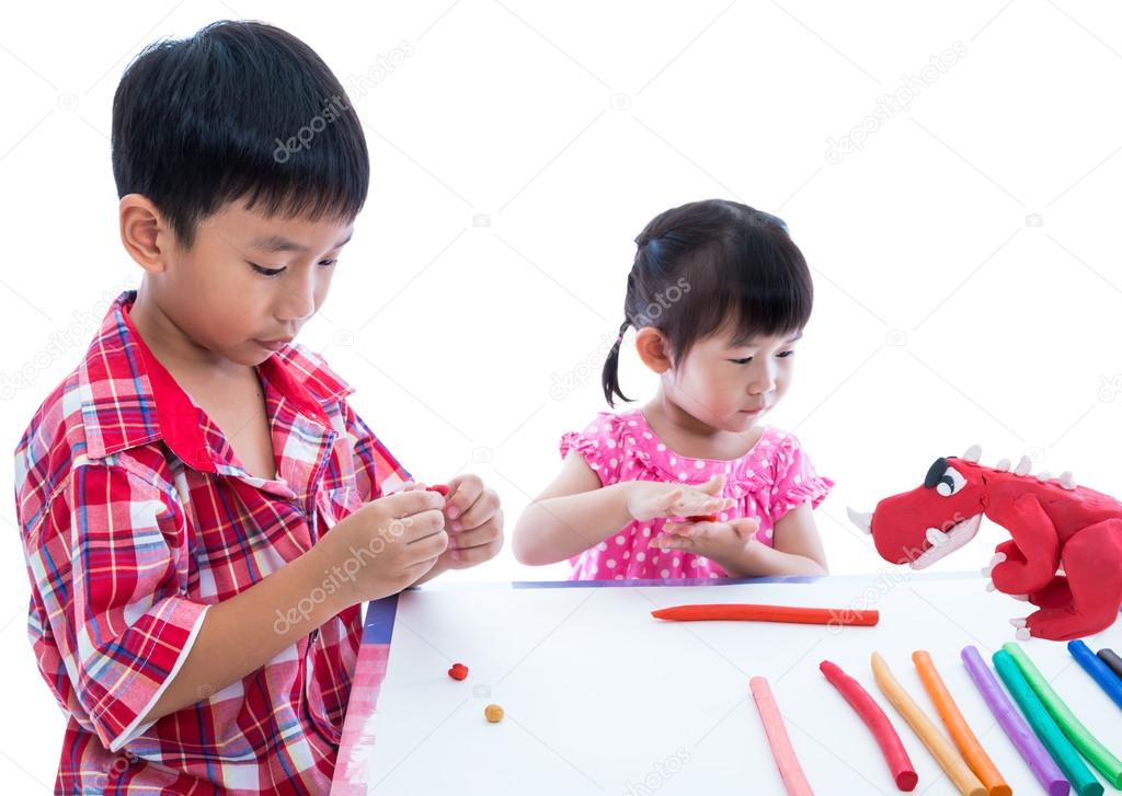 Asian kids playing with play clay on table. Strengthen the imagi