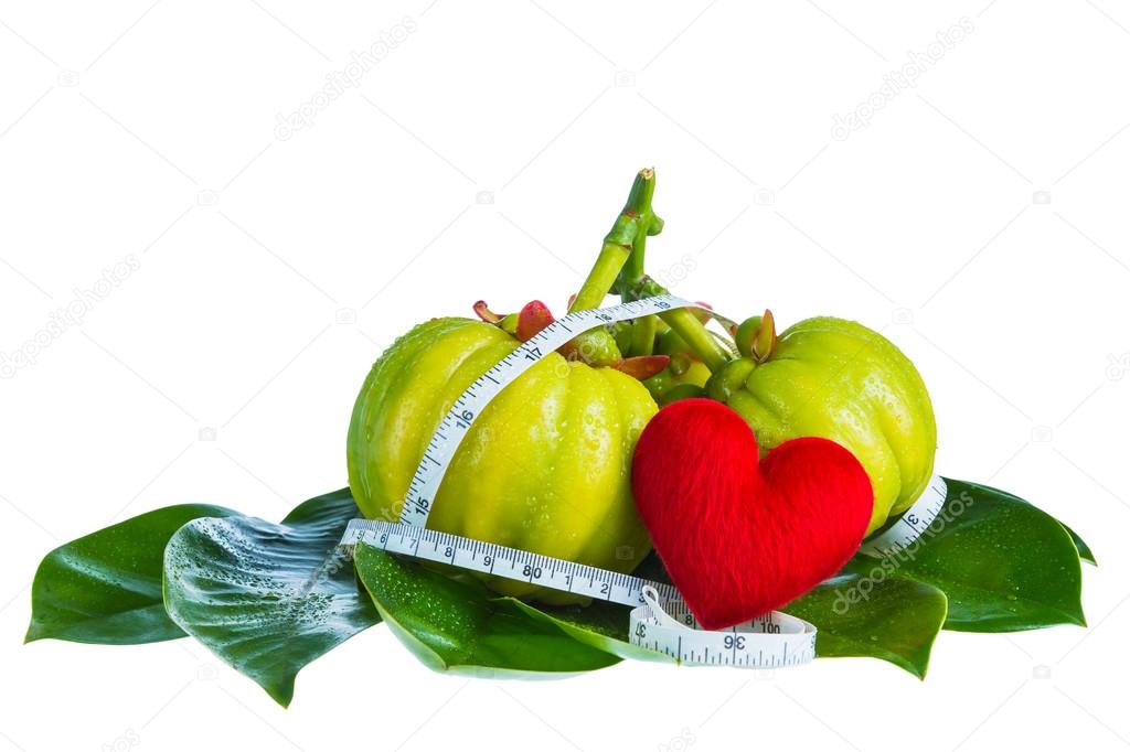 Garcinia cambogia with measuring tape, isolated on white background
