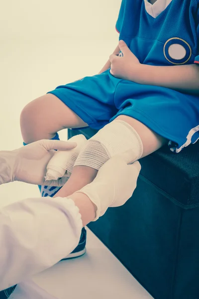 Молодий спортивний хлопчик у блакитній формі. Біль у колінному суглобі . — стокове фото