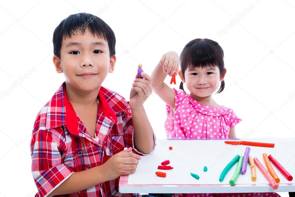 Asian kids playing with play clay on table. Strengthen the imagination of child