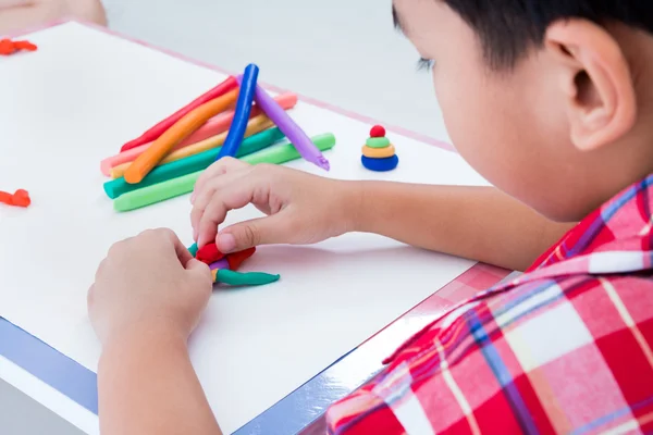 Niño que moldea plastilina, sobre fondo blanco de ballena. Fundidos — Foto de Stock