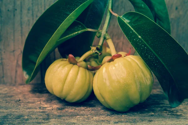 Garcinia cambogia fresca sobre fondo de madera. Tono vintage . — Foto de Stock