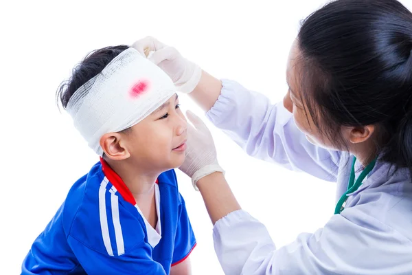 Sports injury. Doctor makes a bandage on head patient, on white. — Stock Photo, Image