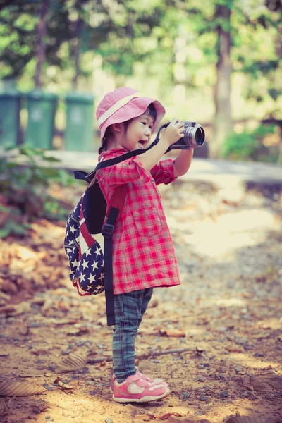 Asian girl taking photos by digital camera in garden. Vintage picture style. — Stock Photo, Image