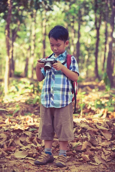 Asian boy checking photos in digital camera. Vintage picture sty — Stock Photo, Image