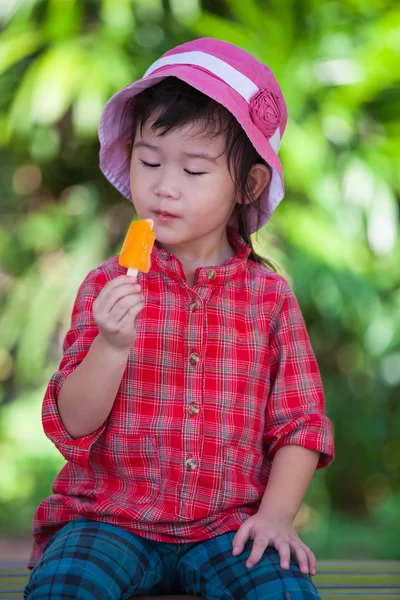 Asiatique fille manger crème glacée en été sur fond de nature floue — Photo