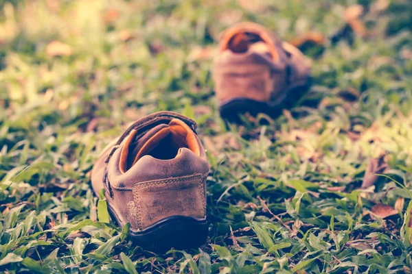 Ένα ζευγάρι παπούτσια από δέρμα για την πράσινη χλόη. Ρετρό στυλ επίδραση. — Φωτογραφία Αρχείου