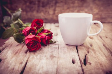 Red roses for Valentine's Day on blurred wooden background. Retr