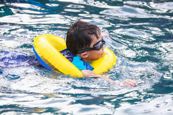 滑稽的亚洲男孩在游泳池游泳管。户外. — 图库照片