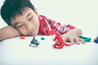 Child sleeping with his works from clay, on white. Strengthen the imagination of child.