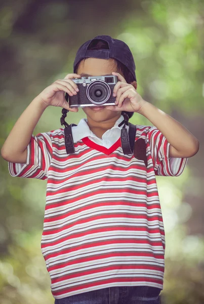 Aziatische jongen fotograaf met professionele digitale camera op de achtergrond van de natuur. — Stockfoto