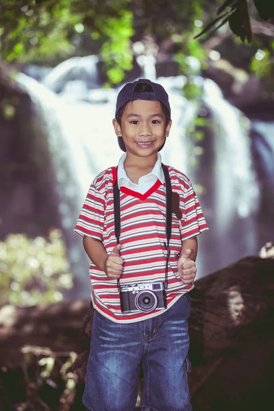 Azjatycki chłopiec fotograf z profesjonalny aparat cyfrowy na wodospad — Zdjęcie stockowe