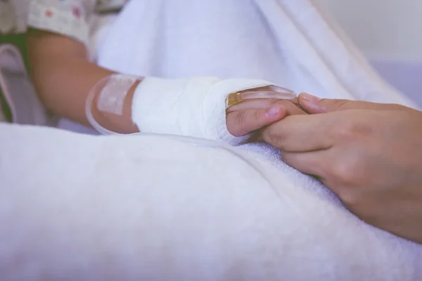 Bliska ręki dominującej trzymając rękę dziecka w szpitalu. W stylu retro — Zdjęcie stockowe