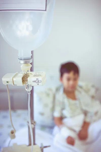 Asiático chico sentado en enfermo cama con infusión bomba intravenosa IV goteo —  Fotos de Stock
