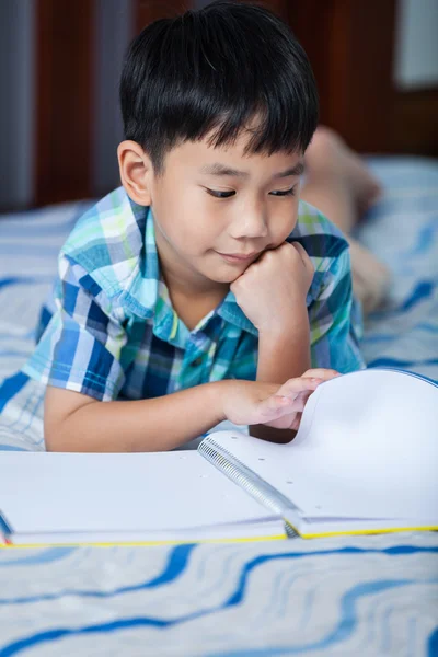Aziatische jongen lezen van een boek. Onderwijs concept. — Stockfoto