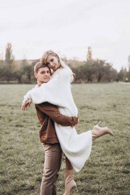 Sonbaharda parkta köpeklerle, Pomeranian 'lılarla gezen güzel bir çift.