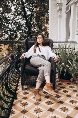 Balkonda beyaz gömlekli güzel bir kızın fotoğrafı.