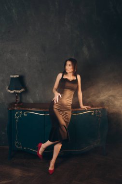 Siyah elbiseli güzel bir kızın fotoğraf stüdyosunda fotoğraf çekimi.